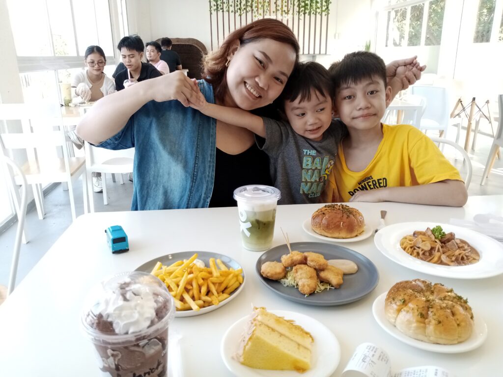 An image of a mother with two kids with the set of meal from Ok Cafe PH