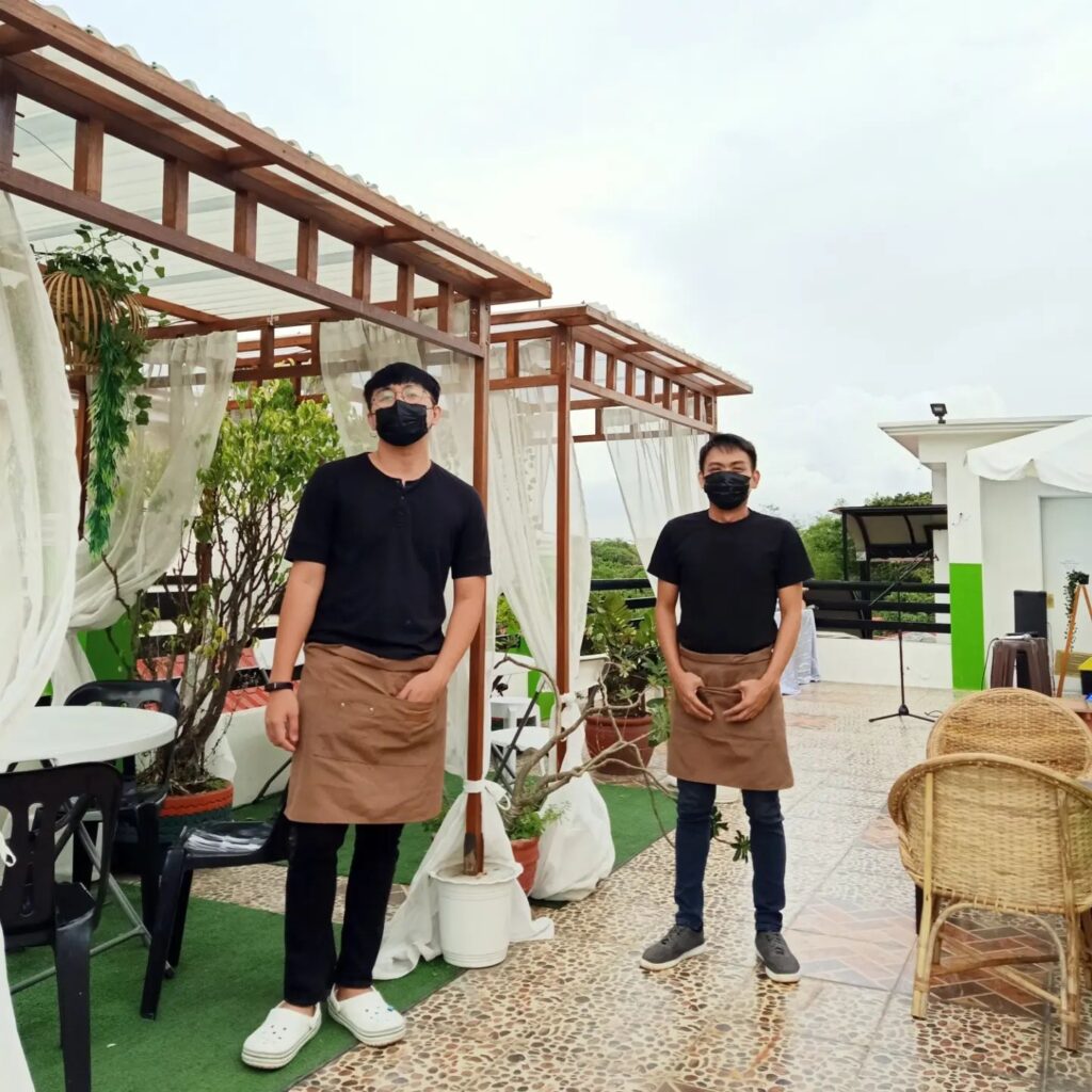 An image of crust and beans roofdeck with two male server