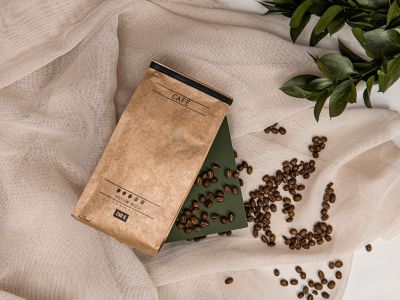 An image of coffee beans over a cloth and paper bag. Disclaimer: Photo Source - Canva